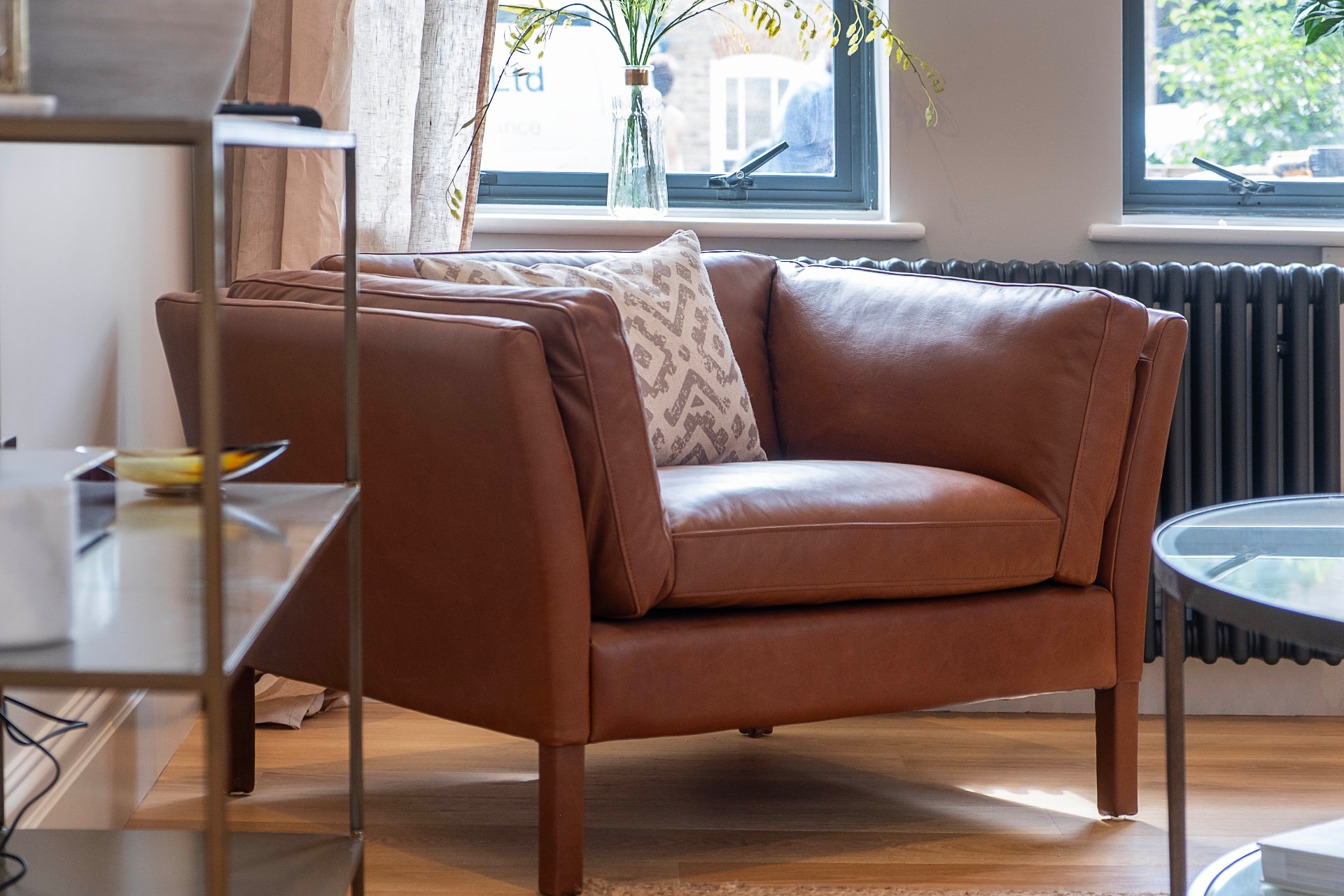 Leather armchair beside tall windows and a black radiator