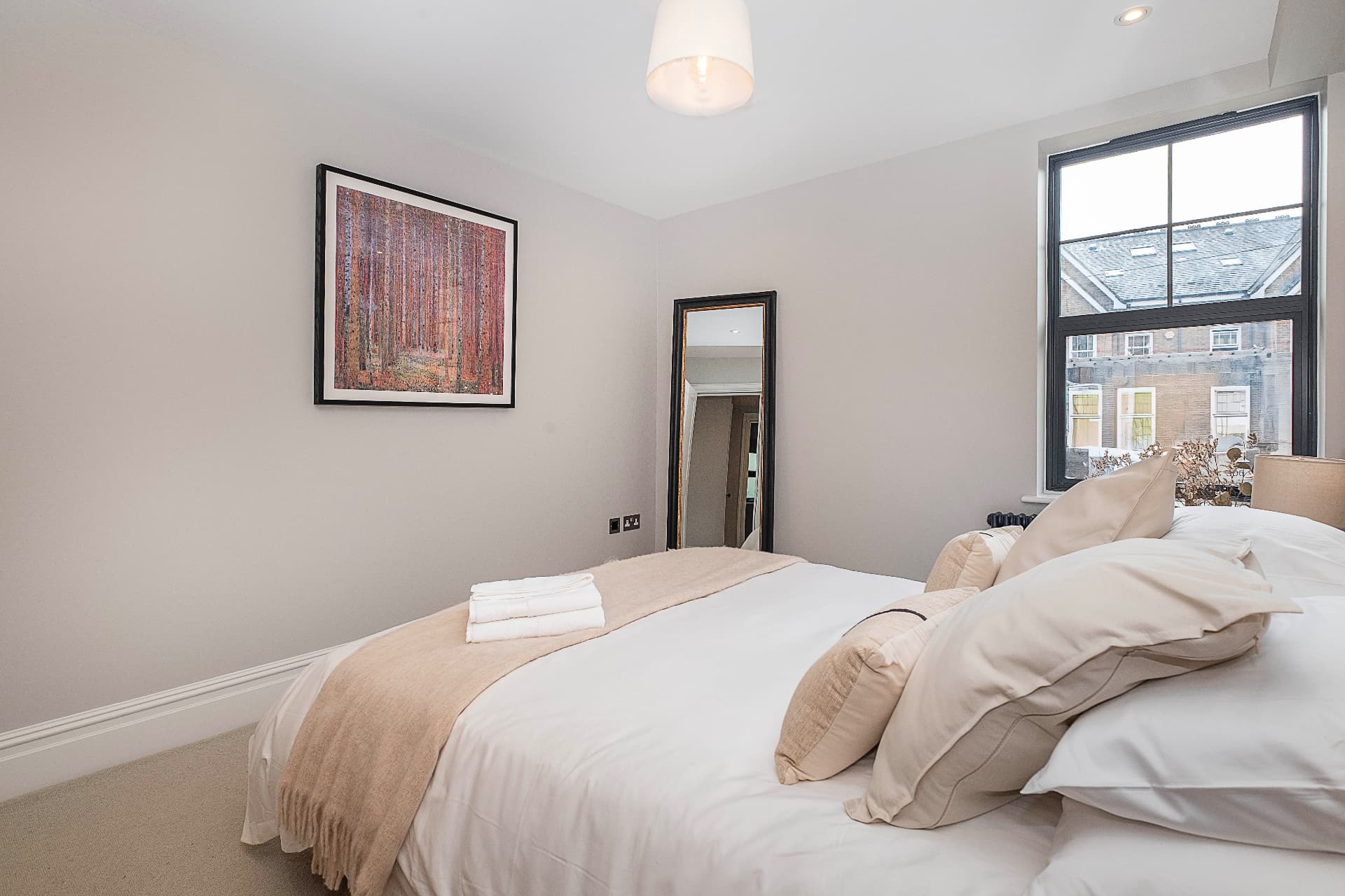Bedroom detail with pillows, an upholstered headboard and a bedside table